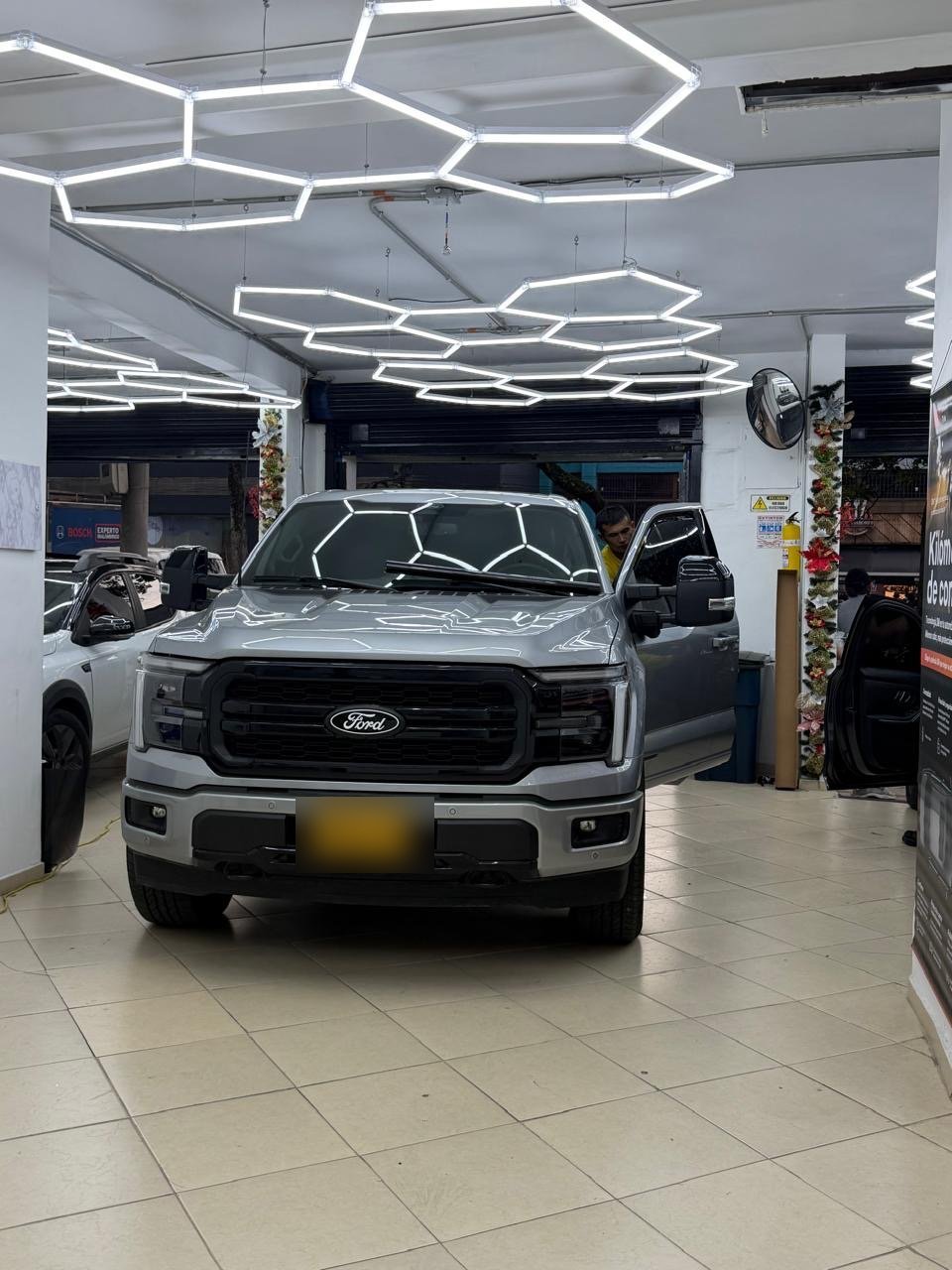 Camioneta Ford F-150 gris en el taller de Security Films con iluminación hexagonal
